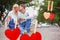 Composite image of cute young couple sitting on skateboard kissing