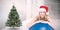 Composite image of festive fit blonde leaning on exercise ball