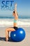 A Composite image of fit woman sitting on exercise ball at the beach stretching arms