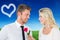 Composite image of handsome man smiling at girlfriend holding a rose