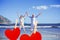 Composite image of happy couple jumping up barefoot on the beach