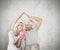 Composite image of happy couple sitting and sheltering piggy bank