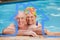 Composite image of happy mature couple in the swimming pool