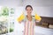 Composite image of happy woman giving thumbs up in rubber gloves