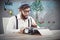 Composite image of hipster holding smoking pipe while working on
