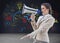 Composite image of irritated stylish brown haired businesswoman screaming in a megaphone