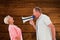 Composite image of man shouting at his partner through megaphone