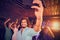 Composite image of man taking a selfie from mobile phone while friends dancing on dance floor