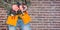 Composite image of manual worker holding gloves and hammer power drill