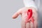 Composite image of midsection of person holding aids awareness ribbon