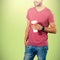 Composite image of midsection of smiling model holding disposable coffee cup