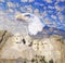 Composite image of Mount Rushmore, bald eagle, U.S. Constitution, and blue sky with white clouds