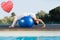 Composite image of peaceful brunette in cobra pose over exercise ball poolside