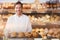 Composite image of portrait of male chef holding tray with bread