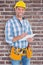 Composite image of portrait of smiling handyman writing on clipboard