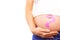 Composite image of pregnant woman holding baby shoes over bump