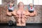 Composite image of rear view of bald man lifting kettlebells