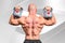 Composite image of rear view of bald man lifting kettlebells