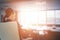 Composite image of rear view of businesswoman holding water glass while sitting on chair