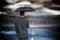 Composite image of rear view of classy businessman holding grey umbrella