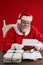 Composite image of santa claus reading wish lists