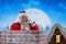 Composite image of santa claus standing beside chimney and talking on mobile phone