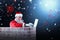 Composite image of santa claus using laptop on chimney