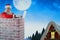 Composite image of santa claus using laptop on chimney