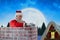 Composite image of santa claus using laptop on chimney