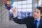 Composite image of serious businessman pointing at cube