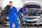 Composite image of smiling male mechanic holding tire