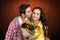 Composite image of smiling woman holding bouquet and being kissed by boyfriend