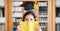 Composite image of woman with book and graduation hat