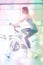 Composite image of woman energetically riding exercise bike