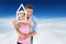 Composite image of young couple hugging and holding house outline