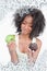 Composite image of young woman hardly hesitating between a muffin and an apple