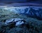 Composite of meadow in rocky mountains at night