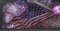 Composition of american flag billowing over purple fireworks in night sky