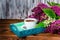 composition with aroma cup of coffee on tray and bouquet beautiful spring lilac, lilies of the valley flowers on brown wooden tab