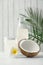 Composition bottle and glass of coconut water on white wooden table