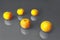 Composition with bright illuminating yellow tangerines on a gray color background.