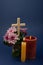 Composition of burning candle, flowers and wooden cross for all souls day. Also suitable for funeral, mourning, grief.