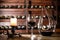 Composition of carafe, glass with wine and canddle. Shelves with wine bottles on a background.