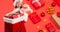 Composition of caucasian woman in santa hat holding christmas presents on red background