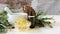 composition of cedar oil with pine nuts on a background of a branch with a pine cone, on a light wooden background