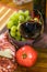 Composition of cheese, bacon, pomegranate, glass of wine and yellow muscat grape on a wooden board