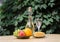 Composition of cheese, grapes, peaches, white , bottles and glasses wine on a wooden round table. in the courtyard.