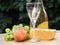 Composition of cheese, grapes, peaches, white , bottles and glasses wine on a wooden round table. in the courtyard.