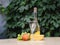 Composition of cheese, grapes, peaches, white , bottles and glasses wine on a wooden round table. in the courtyard.