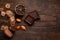 Composition of chocolate two pieces on a wooden background, dried lemon, raisins, plums, pears, walnuts and seeds of